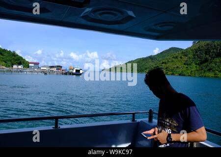 Jemaja, Isole Riau, Indonesia. 22 Maggio, 2019. ANAMBAS, Indonesia - 14 agosto : Un Indonesia utilizzare il telefono cellulare per conect social media isole remote a Kuala Maras isola in isola Anambas regency, isole Riau provincia, Indonesia. In Indonesia il ministro delle Comunicazioni ed informazioni saranno le persone a conect internet appositamente per isole remote in Indonesia. Credito: Sijori Immagini/ZUMA filo/Alamy Live News Foto Stock