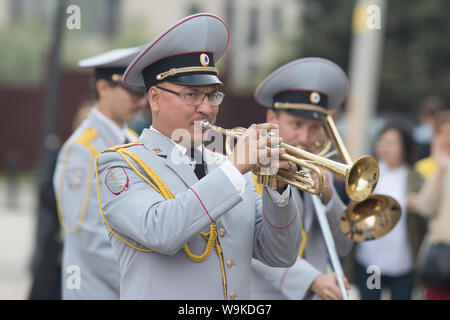 La RUSSIA, KAZAN 09-08-2019: uno strumento a fiato parade - un uomo in costume grigio suonare la tromba Foto Stock