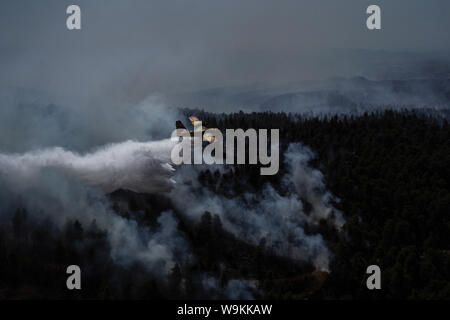 Atene, Grecia. 14 ago 2019. Un aereo spray su un fuoco attiva anteriore vicino villaggio di Stavros, sull isola di Eubea, Grecia, il 14 agosto 2019. In mezzo a continui sforzi per estinguere un incendio distruttivo, Primo Ministro greco Kyriakos Mitsotakis mercoledì chiamati ad una più intensa cooperazione tra l'Unione europea (UE) ai deputati di affrontare in futuro calamità naturali. Egli ha effettuato la chiamata durante una visita a fire-colpite isola Eubea. Credito: Xinhua/Alamy Live News Foto Stock