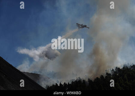 Atene, Grecia. 14 ago 2019. Un aereo spray su un fuoco attiva anteriore vicino villaggio di Stavros, sull isola di Eubea, Grecia, il 14 agosto 2019. In mezzo a continui sforzi per estinguere un incendio distruttivo, Primo Ministro greco Kyriakos Mitsotakis mercoledì chiamati ad una più intensa cooperazione tra l'Unione europea (UE) ai deputati di affrontare in futuro calamità naturali. Egli ha effettuato la chiamata durante una visita a fire-colpite isola Eubea. Credito: Xinhua/Alamy Live News Foto Stock