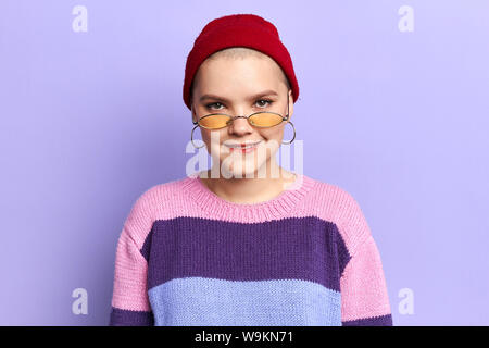 Funny cool confusa ragazza in strisce colorate moda maglione mordere le sue labbra. close up foto. il concetto di stile di vita Foto Stock