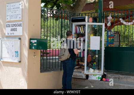 Ajaccio Corsica, 2019-08-France. Resident utilizzando una comunità libera biblioteca, un congelatore riciclato utilizzato per la resistenza agli agenti atmosferici . Foto Stock