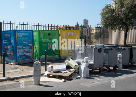 Ajaccio Corsica, 2019-08-Francia.. grande riciclo colorato raccoglitori di strada sulla base di mattoni. Il cartone a sinistra sulla strada pronti per mettere in contenitori. Foto Stock