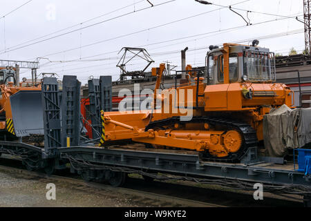 Arancione pesante bulldozer sorge sul pianale del treno per incidente il lavoro di recupero Foto Stock
