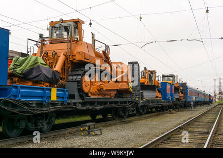 Arancione pesante bulldozer sorge sul pianale del treno per incidente il lavoro di recupero Foto Stock