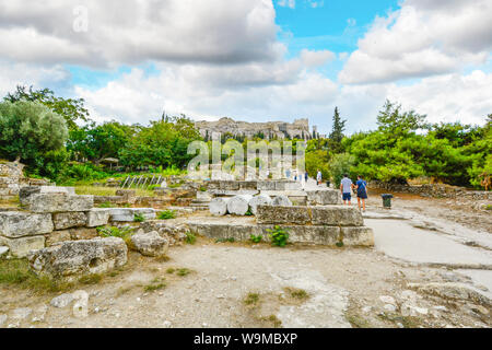 I turisti a piedi attraverso l'antica Agorà greca alla base del colle dell'Acropoli e il Partenone di Atene, Grecia. Foto Stock