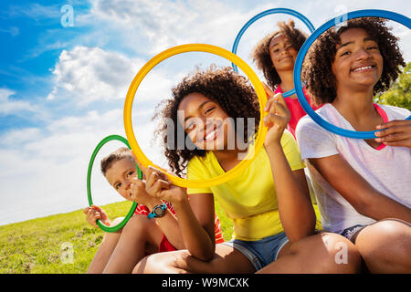 I subacquei guardando i bambini guardano attraverso il cerchio di colore Foto Stock