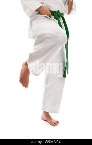 Immagine ravvicinata di al di sotto della sezione di cintura di una ragazza in un kimono con cintura verde preparazione per un ginocchio kick, isolato su sfondo bianco. Foto Stock