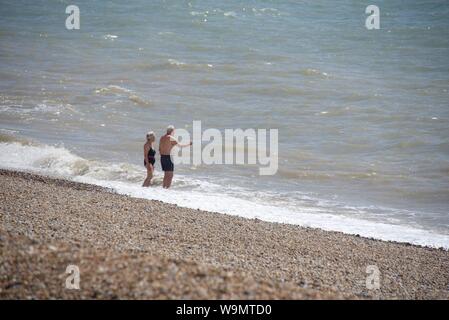 Sandgate, Kent/UK-Luglio 22 2019: una coppia matura venture al bordo dell'acqua del canale inglese off alla costa del Kent Foto Stock