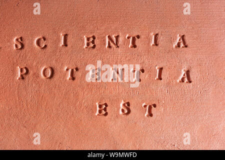 La frase "Scientia est potentia" scritta in latino su una tavoletta di terracotta Foto Stock