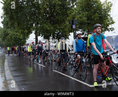 Londra, Regno Unito. 14 Agosto, 2019. Ciclista pendolari sono senza lasciarsi scoraggiare dalla pioggia come su questa bicicletta lane vicino a Westminster Bridge questa sera. Credito: Joe Kuis / Alamy News Foto Stock