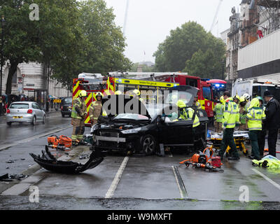 Londra, Regno Unito. 14 Agosto, 2019. In un giorno di gran pioggia questo incidente si è verificato su Whitehall, Westminster questo pomeriggio, con i medici del London ambulanza e vigili del fuoco rilasciando il conducente dal suo posto di guida. Credito: Joe Kuis / Alamy News Foto Stock