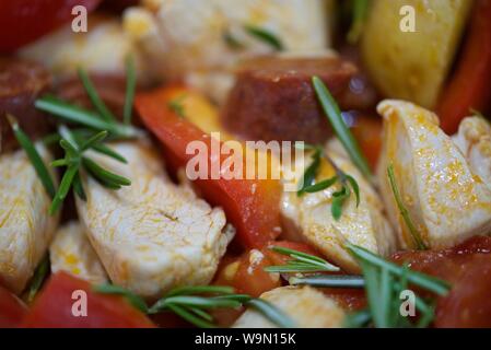 Pollo, chorizo, pomodori tritati pepe rosso, cipolla, Spicchi di patate con Rosmarino e Timo mescolare fritto in olio di oliva prima di andare in forno Foto Stock