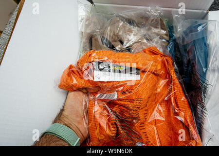 Parigi, Francia - Giu 28, 2019: Man mano unboxing nuove Nike Running vestiti guardando la plastica avvolto in borsa Foto Stock