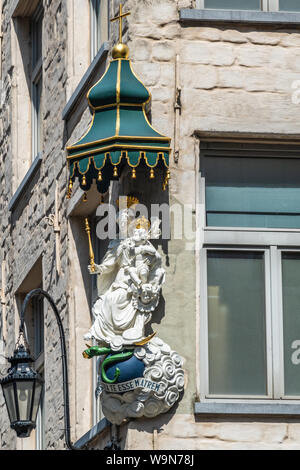 Antwerpen, Belgio - 23 Giugno 2019: Closeup di pietra bianca con corone d'oro statua della Madonna con bambino su un angolo di Eiermarkt e Suderman Straat. Foto Stock