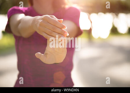 Giovane donna fitness runner mano stretching prima di correre nel parco. Outdoor esercitare attività di concetto. Foto Stock