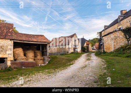 Strada di ghiaia passando attraverso le antiche case coloniche francese Foto Stock