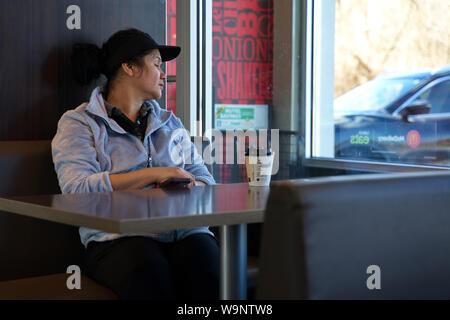 Middletown, CT, Stati Uniti d'America. Apr 2019. Un dipendente di clock in attesa di lei ride home prende un breve pisolino. Foto Stock