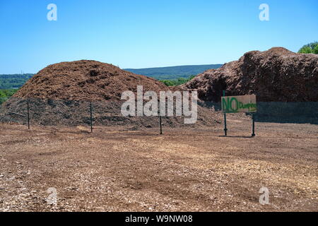 Un assenza di pratiche di dumping il segno inviato a un recintato in pile delle importazioni oggetto di dumping di strame. Foto Stock