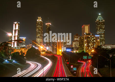 Città sveglio - Lunga esposizione di Atlanta skyline notturno con luce percorsi di traffico in primo piano. Foto Stock