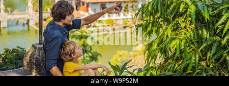 Papà e figlio in acqua Palace Soekasada Taman Ujung rovine sulla isola di Bali in Indonesia. Incredibile architettura antica. Viaggi e vacanze sfondo Foto Stock