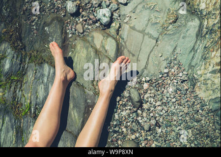 Le gambe di una giovane donna in appoggio sulla spiaggia in estate Foto Stock