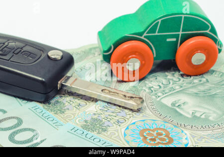 Valuta polacca denaro, verde auto giocattolo e la chiave veicolo. Acquisto o vendita di concezione del veicolo Foto Stock