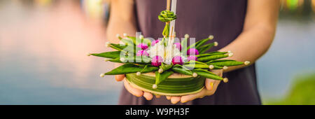 BANNER, formato lungo un turista femminile detiene il Loy Krathong nelle sue mani ed è in procinto di avviare nell'acqua. Loy Krathong festival, la gente acquista Foto Stock