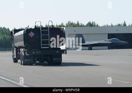 Avieri assegnato alla 673d disponibilità logistica Squadron guidare un carrello del carburante come un F-22 Raptor della 525th Fighter Squadron (Bulldogs) taxiis su base comune Elmendorf-Richardson, Alaska, e il Agosto 9, 2019. Gli specialisti di combustibili di gestire ogni singolo aspetto del rifornimento ogni aereo sul volo di linea e sono responsabili per il funzionamento dei veicoli, le attrezzature e le strutture di magazzinaggio che sono essenziali per le operazioni di rifornimento, garantendo al tempo stesso la conformità con tutte le norme di sicurezza durante la manipolazione di questi liquidi volatili.(STATI UNITI Air Force foto/Justin Connaher) Foto Stock