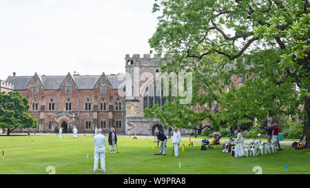 Pozzetti, Inghilterra - Giugno 12, 2019: Senior i membri del team di un locale Croquet Club godono di un gioco nei giardini del Palazzo dei Vescovi nella città di Somerset Foto Stock