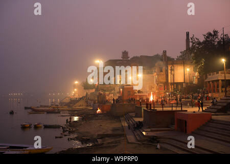 Pellegrini indù sulla masterizzazione Harishchandra ghat di Varanasi (India). Varanasi è la più santa tra le sette città sacra in India Foto Stock