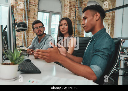 Risultato del progetto. Team multi etnico discutere di affari mentre si lavora insieme in moderno spazio aperto. Il concetto di lavoro. Sul posto di lavoro. Lavoro di squadra Foto Stock