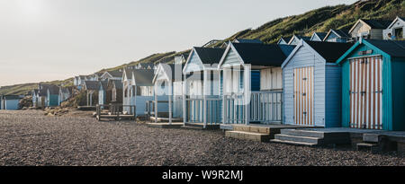 Milford on Sea, Regno Unito - 13 Luglio 2019: vista panoramica di capanne sulla spiaggia al tramonto in Milford sul mare, un tradizionale villaggio inglese famoso per cl mozzafiato Foto Stock