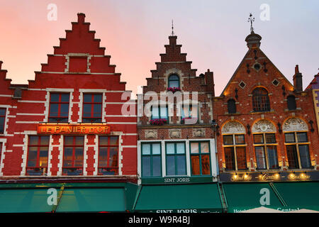 Le case delle corporazioni convertito in ristoranti al tramonto in piazza del mercato o Markt, Bruges, Belgio Foto Stock