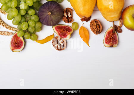 Creative autunno composizione con frutta, foglie e wallnuts bianco su sfondo di legno, vista dall'alto Foto Stock
