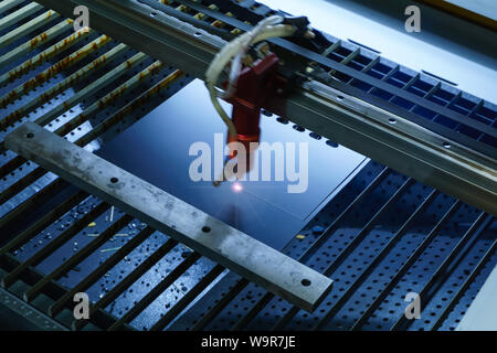 Fase del processo di produzione di schede a circuito stampato - taglio laser in modalità automatica, emettitore è sfocata in movimento Foto Stock