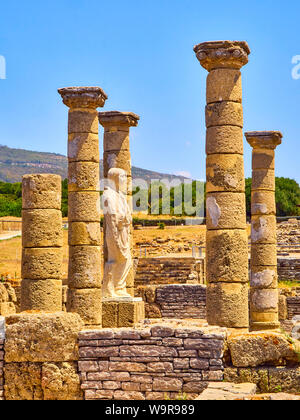 Resti della Basilica principale e la statua dell'Imperatore Traiano in Baelo Claudia sito archeologico. Tarifa, Cadice. Andalusia, Spagna. Foto Stock