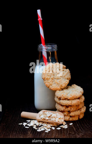 Farina di avena cookie, fiocchi di avena e bottiglia di latte Foto Stock