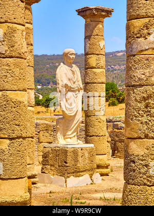 Resti della Basilica principale e la statua dell'Imperatore Traiano in Baelo Claudia sito archeologico. Tarifa, Cadice. Andalusia, Spagna. Foto Stock