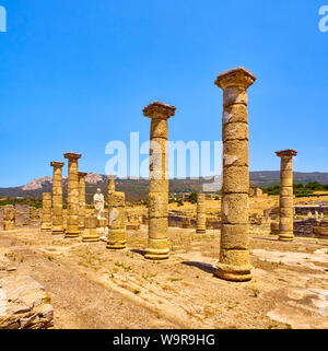 Resti della Basilica principale e la statua dell'Imperatore Traiano in Baelo Claudia sito archeologico. Tarifa, Cadice. Andalusia, Spagna. Foto Stock