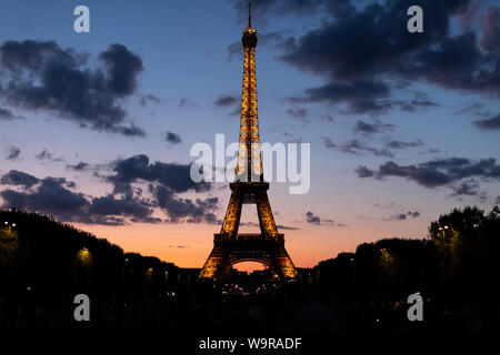 La Torre Eiffel a Parigi Francia è illuminato come lo è ogni notte. Foto Stock