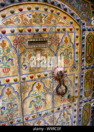 Marrakech Maroc Aprile 02,2010: multicolore di legno arabo porta di ingresso con una porta di ferro della manopola e uno slot di posta elettronica Foto Stock