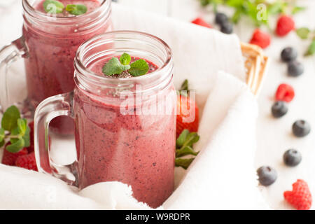 Berry mix potein cioccolato frullati in Mason jar su sfondo chiaro Foto Stock