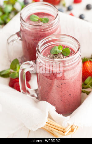 Berry mix potein cioccolato frullati in Mason jar su sfondo chiaro Foto Stock
