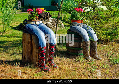 Blumendekoration, kurios, Jeans, Stiefel Foto Stock