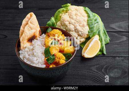 , Aloo Gobi con riso e chapati. Cucina indiana curry vegetariani cucinati con cavolfiore, patata, zenzero, aglio e spezie - cumino, coriandolo, peperoncino Foto Stock