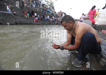 Kathmandu, Nepal. Il 15 agosto, 2019. Devoto nepalese offrendo la preghiera rituale durante Janai Purnima festival o Rakchhya Bandhan al tempio di Pashupatinath, Kathmandu, Nepal, giovedì 15 agosto, 2019. Janai Purnima, noto anche come il filetto sacred festival o Rakshya Bandhan festival indù, gli uomini, specialmente i Brahmans e Chettris, eseguire la loro variazione annua di Janai, sacro fili usurati lungo il petto o legato attorno al polso. Purificato mediante i mantra, il thread è un simbolo di protezione, secondo la credenza indù. Credito: Pacific Press Agency/Alamy Live News Foto Stock