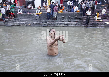 Kathmandu, Nepal. Il 15 agosto, 2019. Devoto nepalese offrendo la preghiera rituale durante Janai Purnima festival o Rakchhya Bandhan al tempio di Pashupatinath, Kathmandu, Nepal, giovedì 15 agosto, 2019. Janai Purnima, noto anche come il filetto sacred festival o Rakshya Bandhan festival indù, gli uomini, specialmente i Brahmans e Chettris, eseguire la loro variazione annua di Janai, sacro fili usurati lungo il petto o legato attorno al polso. Purificato mediante i mantra, il thread è un simbolo di protezione, secondo la credenza indù. Credito: Pacific Press Agency/Alamy Live News Foto Stock