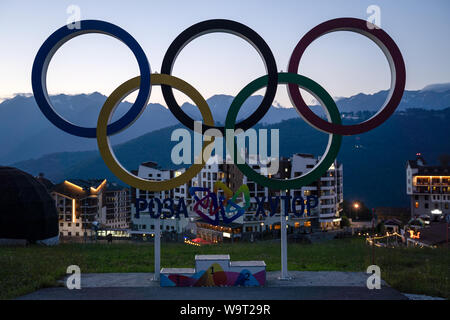 Russia, Sochi - Luglio 4, 2019: Colorful anelli olimpici nel villaggio olimpico in Rosa Khutor, cielo blu al tramonto. Foto Stock