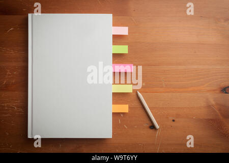 Coperchio cieco libro e una matita su un tavolo di legno Foto Stock